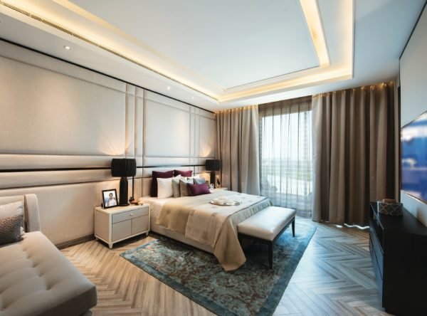 Master bedroom with panelled headboard wall and herringbone oak floor