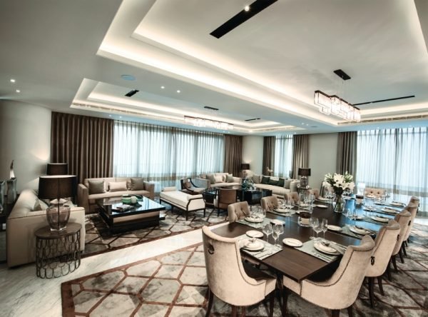 Expansive living and dining room of a sky residence with layered lighting