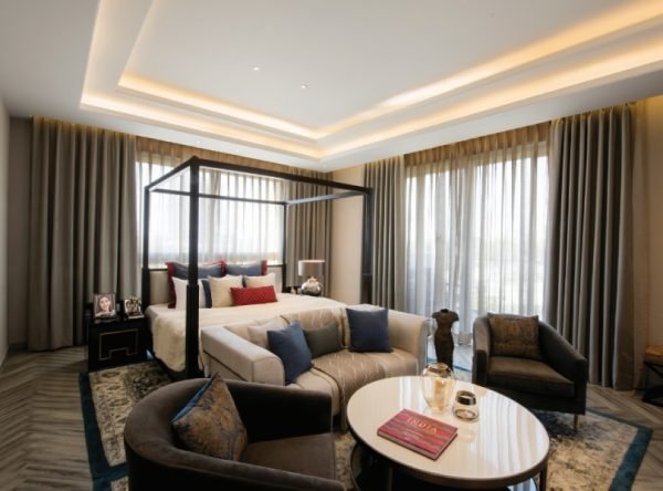 Four-poster bedroom suite with a seating area and full-height windows